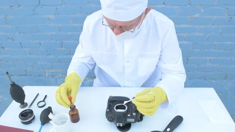 Elderly solid person in white dressing gown, cap, medical mask, glasses clean Stock Footage 93429206