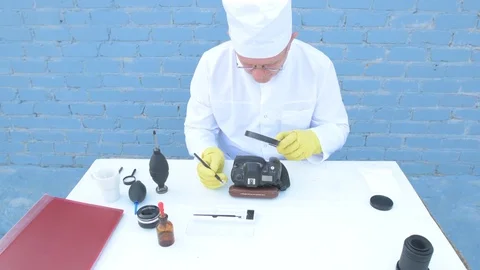 Elderly solid person in white dressing gown, cap, medical mask, glasses clean Stock Footage 93429445