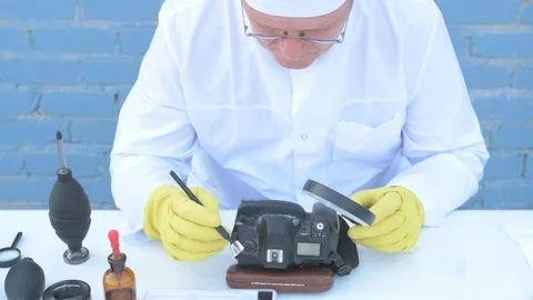 Elderly solid person in white dressing gown, cap, medical mask, glasses clean Stock Footage 93429460