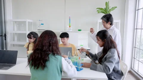 Elderly teacher teaching science Introducing female students in classroom U.. Stock Footage 255717922