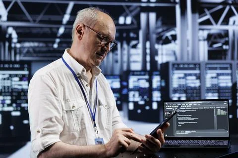 Elderly technician coding in data center 스톡 사진