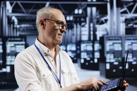 Elderly technician examining servers Foto stock