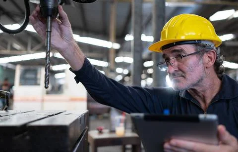 An elderly technician uses a computer to test the operation control of a s... Stock Photos