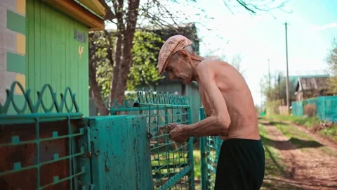 An elderly thin man is digging in an iron booth. Gardening. Stock Footage 162193604