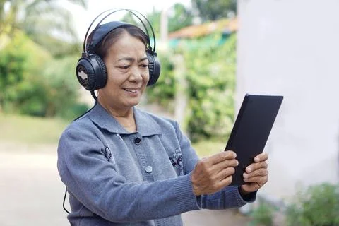 Elderly use technology smart device. Relax with online music Stock Photos
