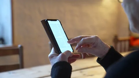 Elderly using phone to read the news 動画素材 230233759