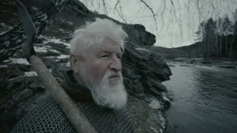 ​​Elderly Warrior Standing with Axe, Overlooking River and Rocky Landscape Stock Footage 295533125