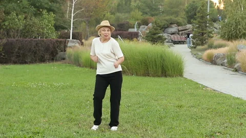 Elderly woman dancing on the street. The concept of positive old age Stock Footage