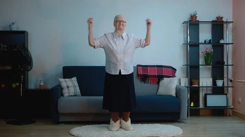 An elderly woman does exercises while in the room Stock Footage 127287183