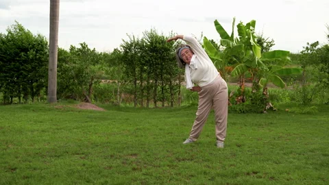 An elderly woman doing exercise in the backyard in the morning. Stock Footage 137687675