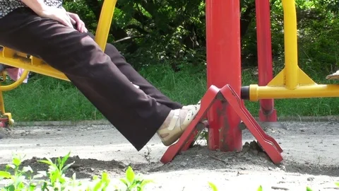 Elderly woman doing exercises on the simulators in the park. Video stock 76709927