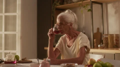 Elderly Woman with Glucose Sensor Patch Enjoying Tea at Kitchen Table Vídeos de archivo 320971892