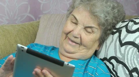 Elderly woman holds a digital tablet indoors Stock Footage 67158053