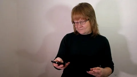 Elderly woman inserts data from a bank card into smarfon Stock Footage 83096320