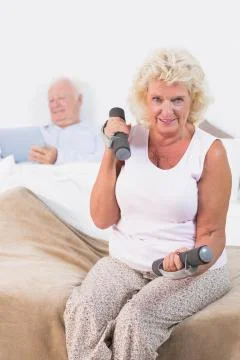 Elderly woman lifting dumbbells Stock Photos