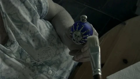 An elderly woman lightly dusts a Sun faced ornament. Not B&amp;W Stock Footage 72931753