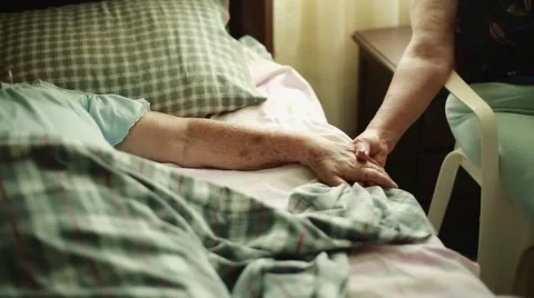 Elderly Woman lying down and holding another woman's hands Video stock 47487553