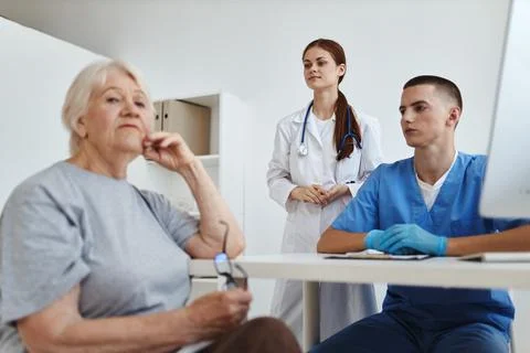 Elderly woman patient in the doctor's office service assistant Stock Photos
