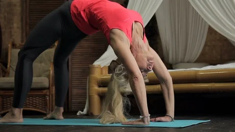 Elderly woman performs bridge exercise on floor in bedroom in morning. Video stock 88269708