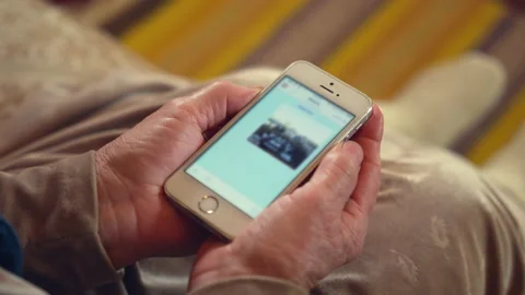 Elderly woman rests on sofa checking photo message in chat Stock Footage 231779460