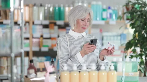 Elderly woman scanning qr code of paracetamol Stock Footage 312229071