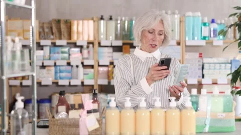 Elderly woman scanning qr code of cream Stock Footage 331297488