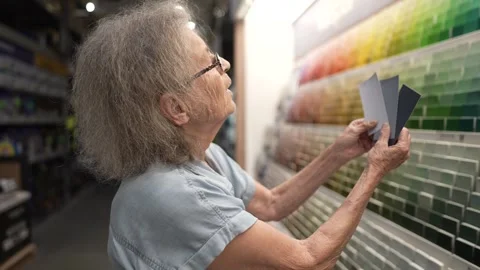 Elderly Woman Selecting Paint Colors in Hardware Store for Home Decoration Stock Footage 313806053