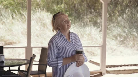 An elderly woman stands on the terrace o… | Stock Video | Pond5