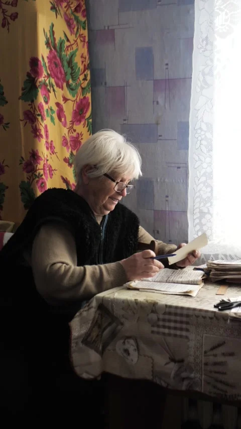 An elderly woman studies payment documents. Utility bill records. Stock Footage 325820904