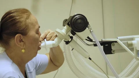 Elderly woman undergoing pulmonary function test in hospital 動画素材 325387899