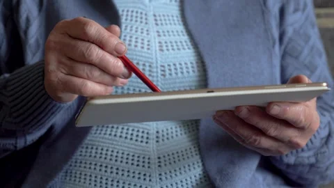 Elderly woman using digital pen on tablet close up Stock Footage 312006312