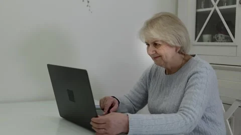 Elderly woman using laptop computer at home Stock Footage 321855756