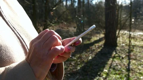 Elderly Woman Using Smartphone In Spring Forest Stock Footage