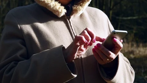 Elderly Woman Using Smartphone In Spring Forest Stock Footage