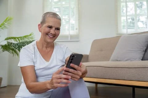 Elderly Woman Using Smartphone While Practicing Yoga at Home, Combining Modern Foto stock