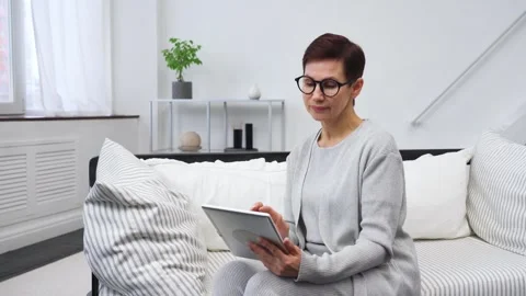 An elderly woman using a tablet. Stock Footage 305975458