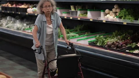 Elderly Woman Using Walker While Grocery Shopping in Supermarket Produce Aisle Stock Footage 313634104