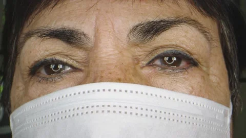 Elderly woman's eyes while wearing protective face mask Stock Footage 130543874