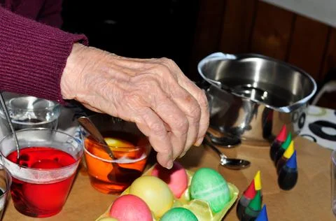 Elderly Woman's Hand Reaching For Easter Egg Foto stock