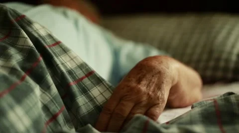 Elderly Woman's hands and mid body as she lays down Stock Footage 47487317