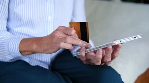 Elderly womans hands closeup using tablet holding credit card buy on internet Stock Footage 159786224