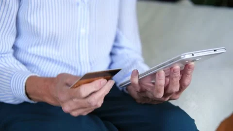 Elderly womans hands closeup using tablet holding credit card buy on internet Video stock 165985731