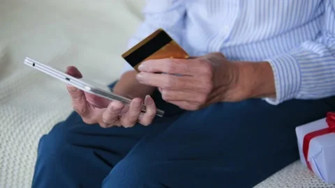 Elderly womans hands closeup using tablet holding credit card buy on internet Video stock 165985760