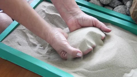 Elderly woman's hands digging in the sand in a box Stock Footage 139919710