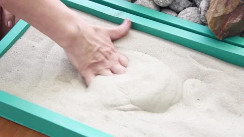 Elderly woman's hands digging in the sand in a box Stock Footage 139919848