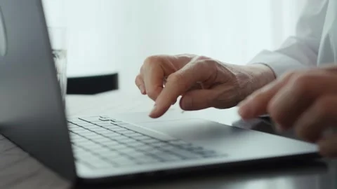 An elderly woman's hands typing on a keyboard close-up. Stock Footage 242140935
