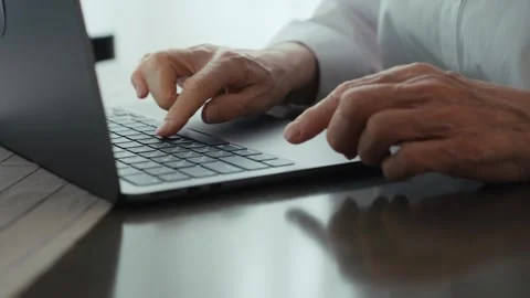 An elderly woman's hands typing on a keyboard close-up. Stock Footage 242140952