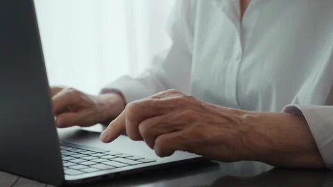 An elderly woman's hands typing on a keyboard close-up. Stock Footage 242140989