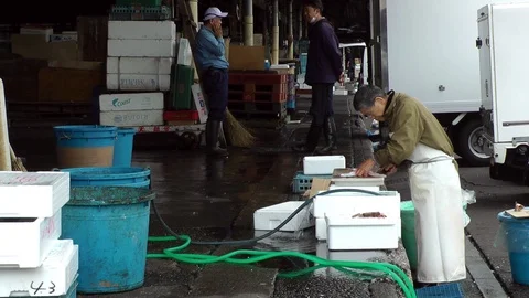 An elderly worker performs his job at the Tsukiji fish market Stock Footage 86588315