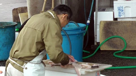 An elderly worker performs his job at the Tsukiji fish market Stock Footage 86588657